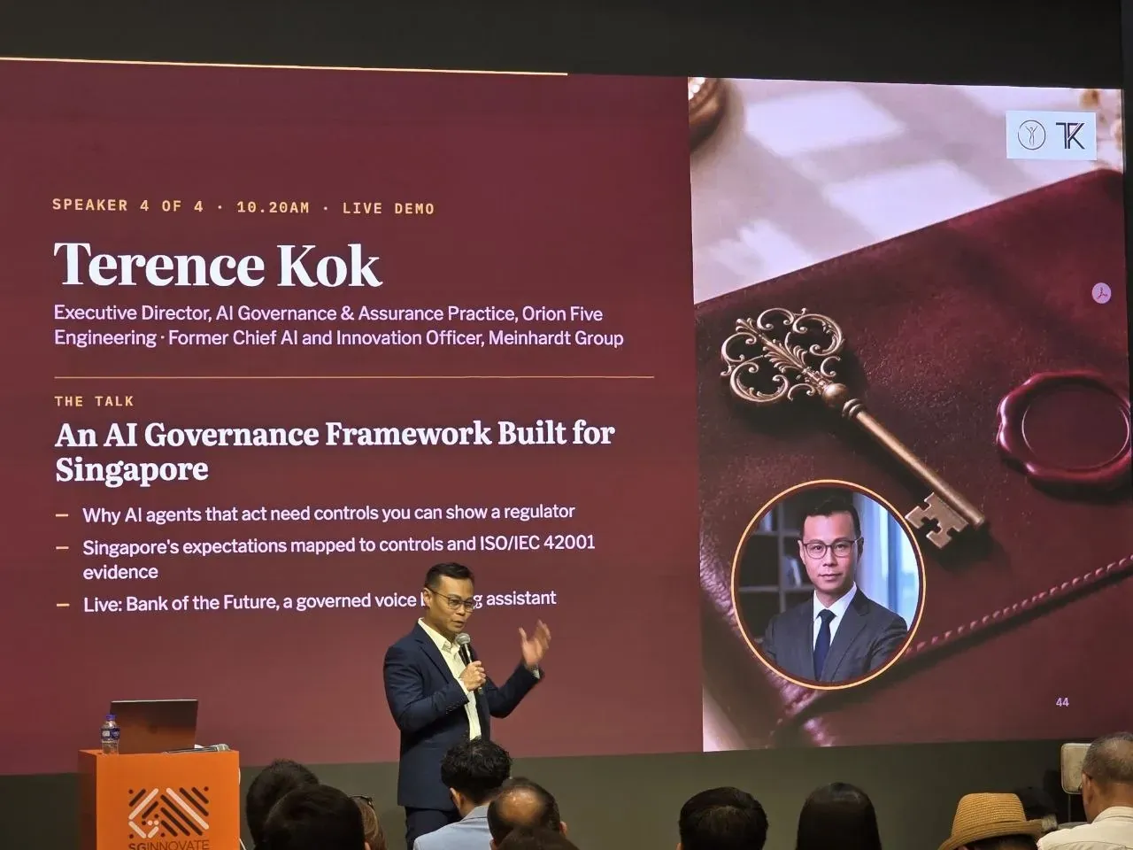 Terence Kok presenting in front of a title slide reading An AI Governance Framework Built for Singapore, with attendees in the foreground.