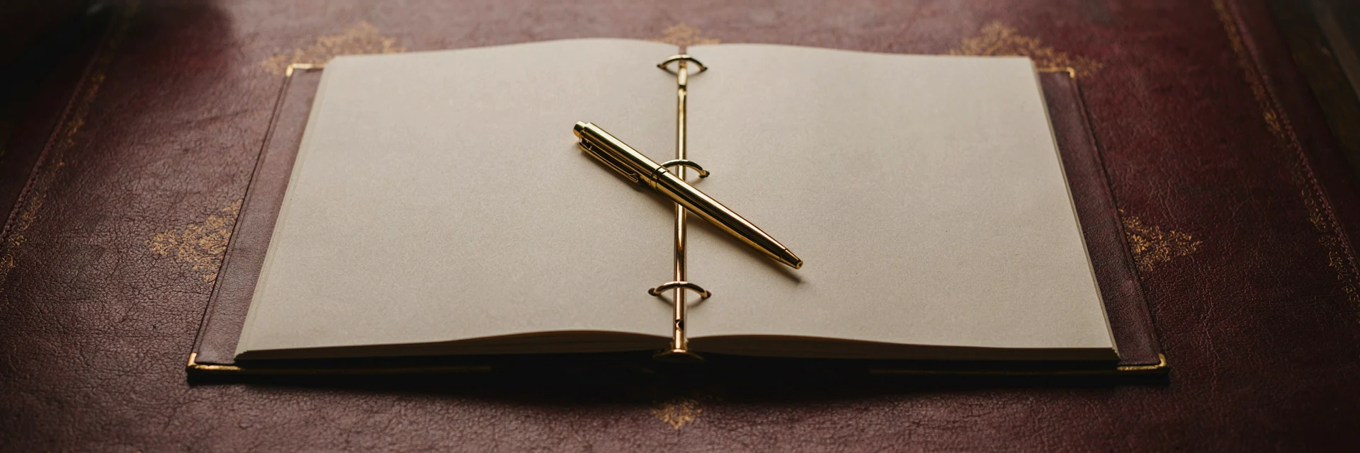 A bound roadmap document open on a desk, a gold pen resting across its pages.
